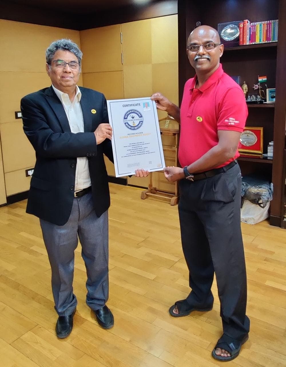 Bobba Ravinder Reddy being awarded a certificate in front of the GAIL office signage
