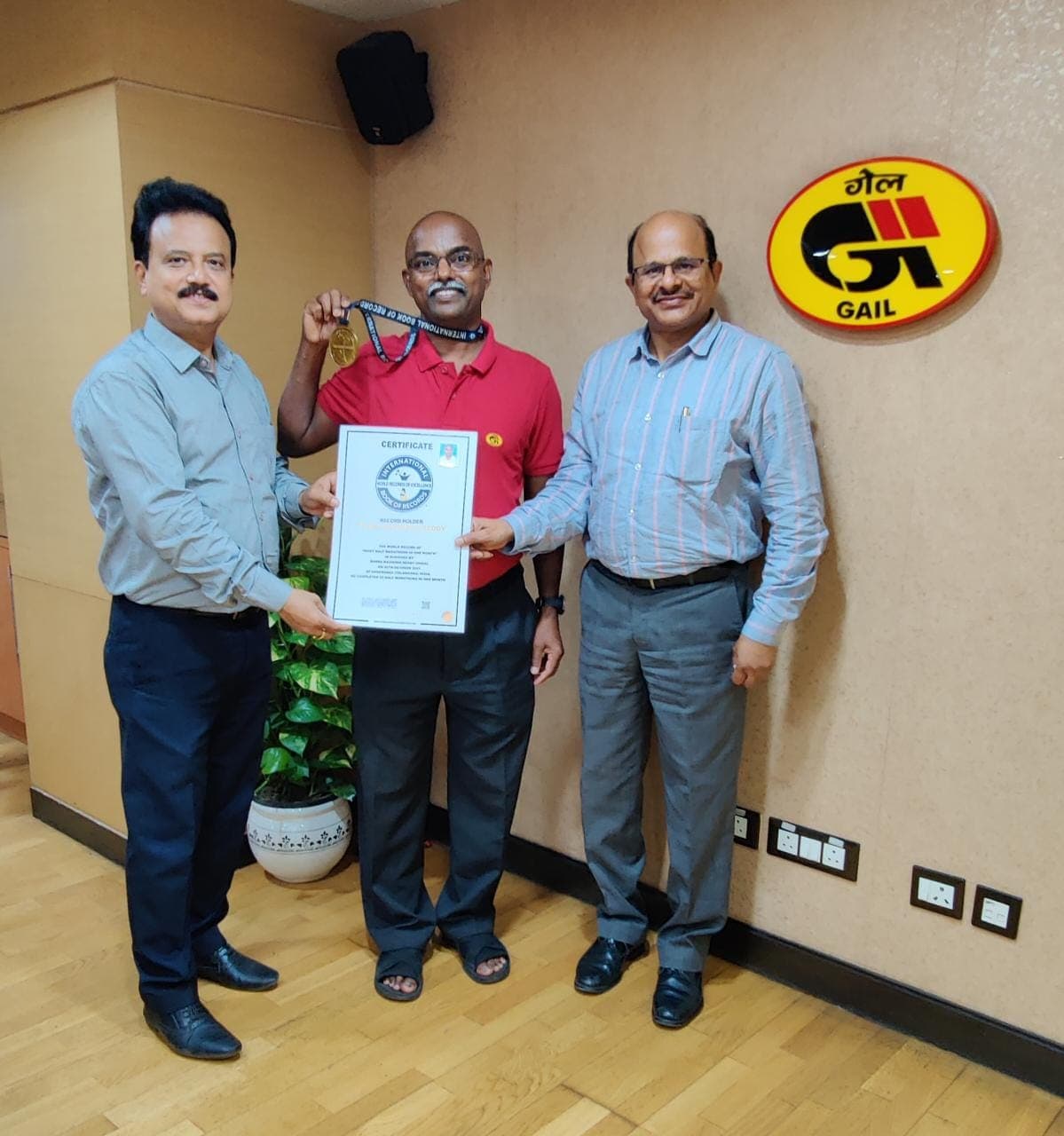 Certificate presentation at an office with a trophy shelf in the background