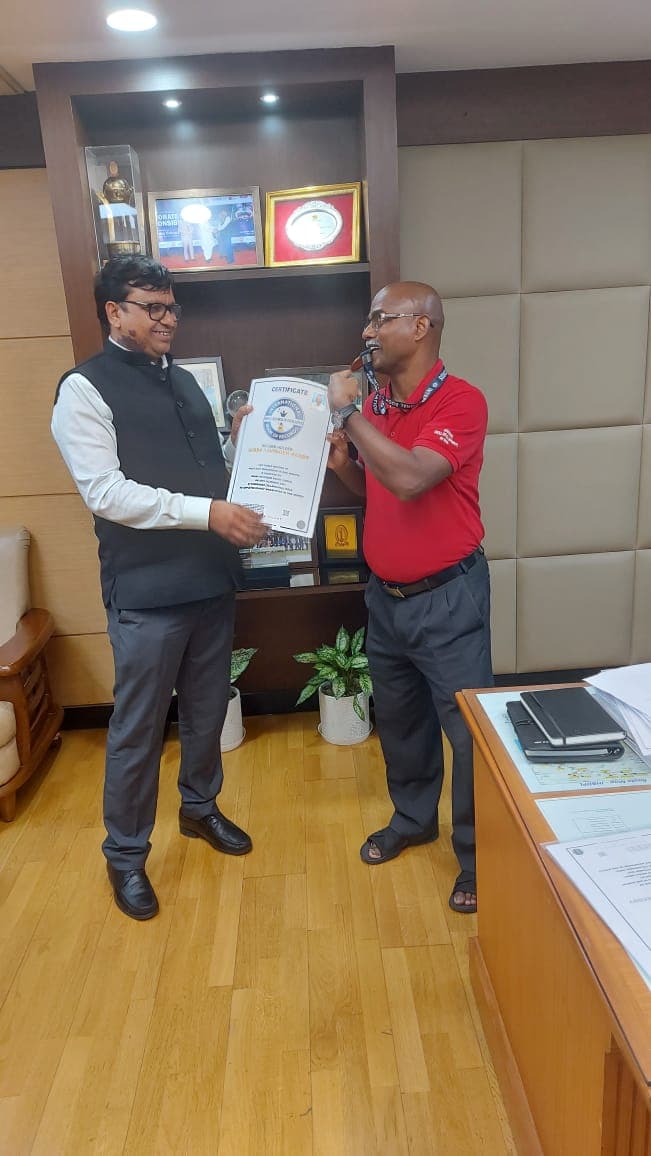 A colleague placing a medal around Bobba Ravinder Reddy's neck at an office celebration