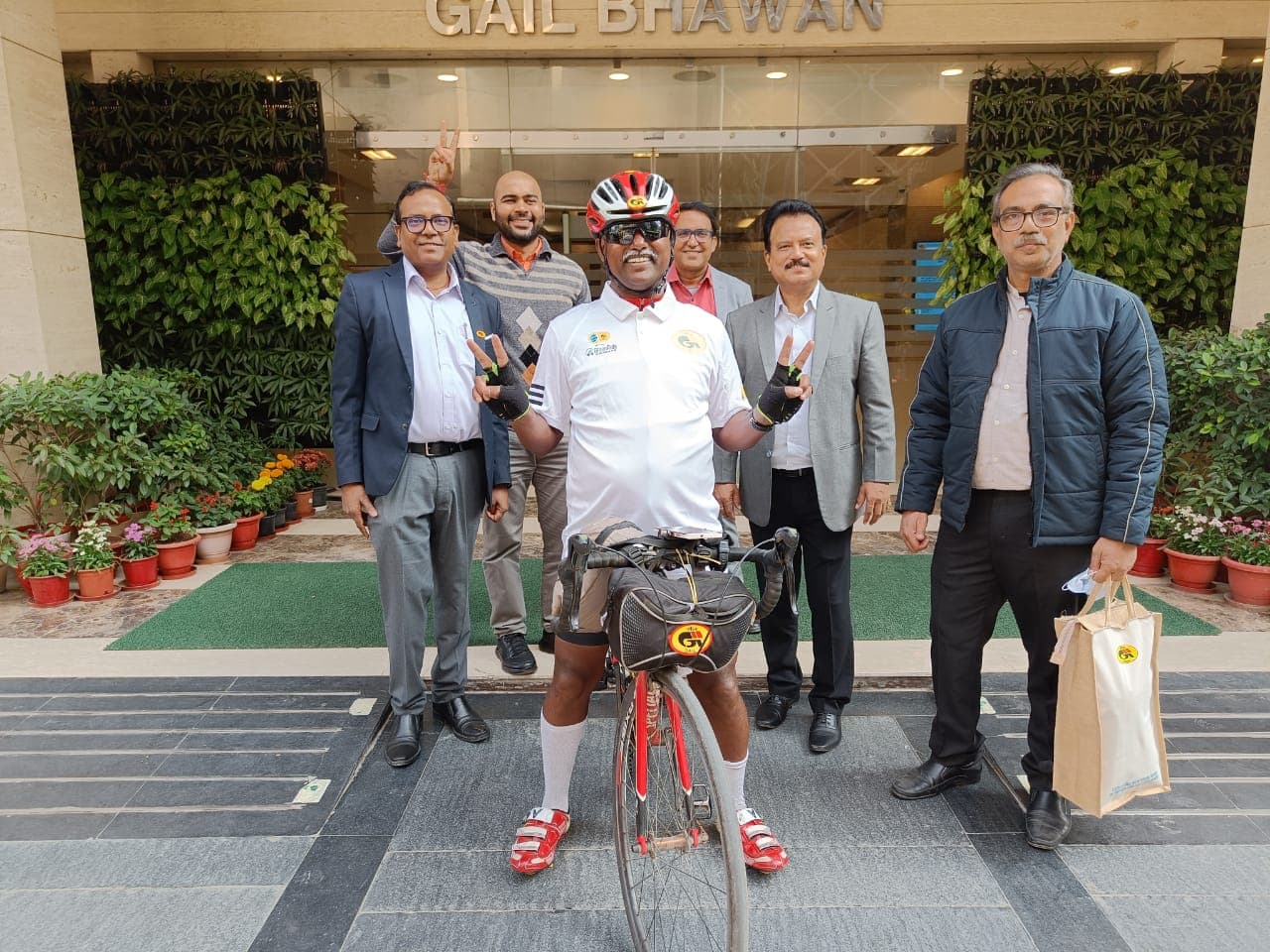 Bobba Ravinder Reddy giving victory signs with GAIL officials in front of the GAIL Bhawan entrance