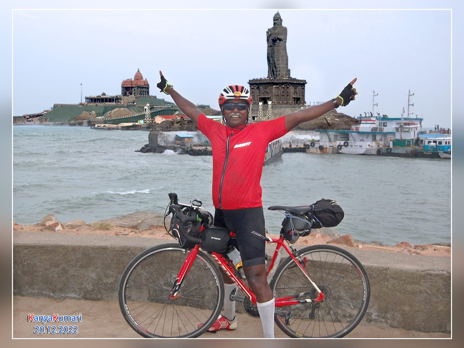 Bobba Ravinder Reddy celebrating with arms raised at Kanyakumari, the Vivekananda Rock Memorial in the background, marking the finish of his Kashmir-to-Kanyakumari solo cycling record on 20 December 2022