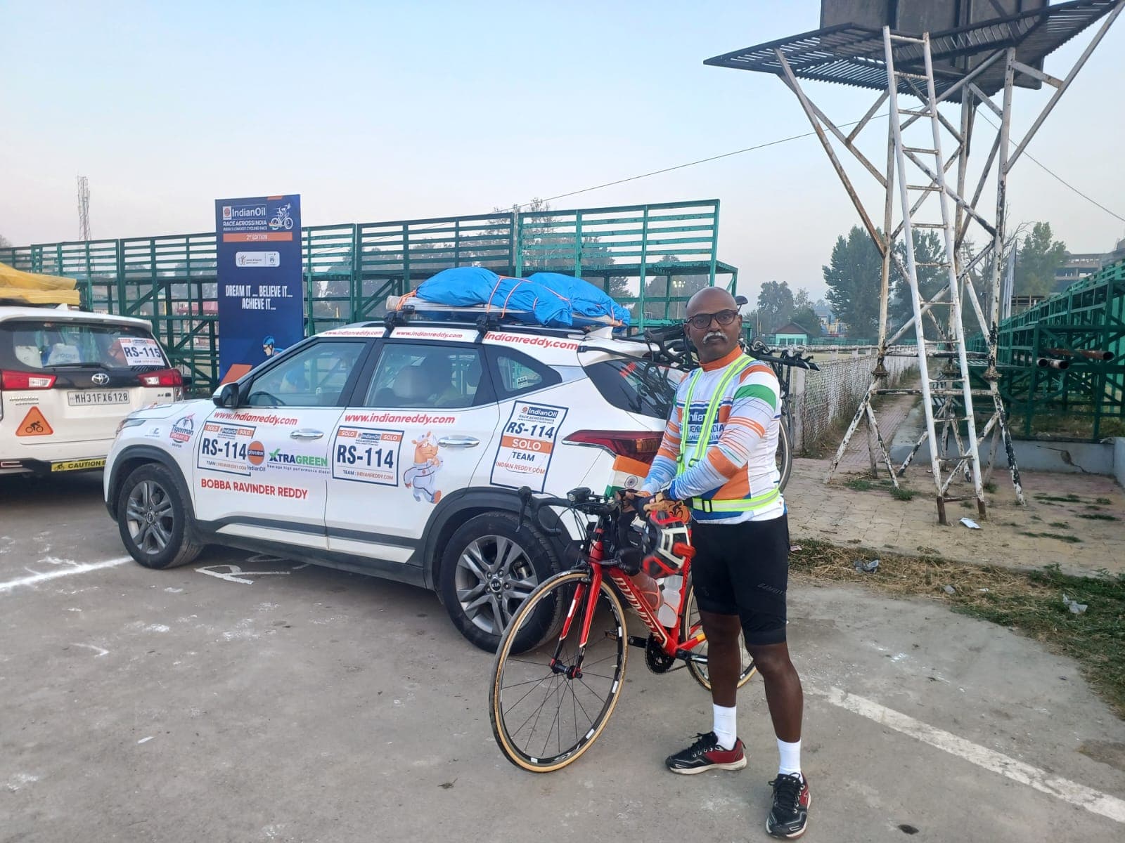 Bobba Ravinder Reddy with his bicycle and RS-114 support car at a stadium before the IndianOil Race Across India