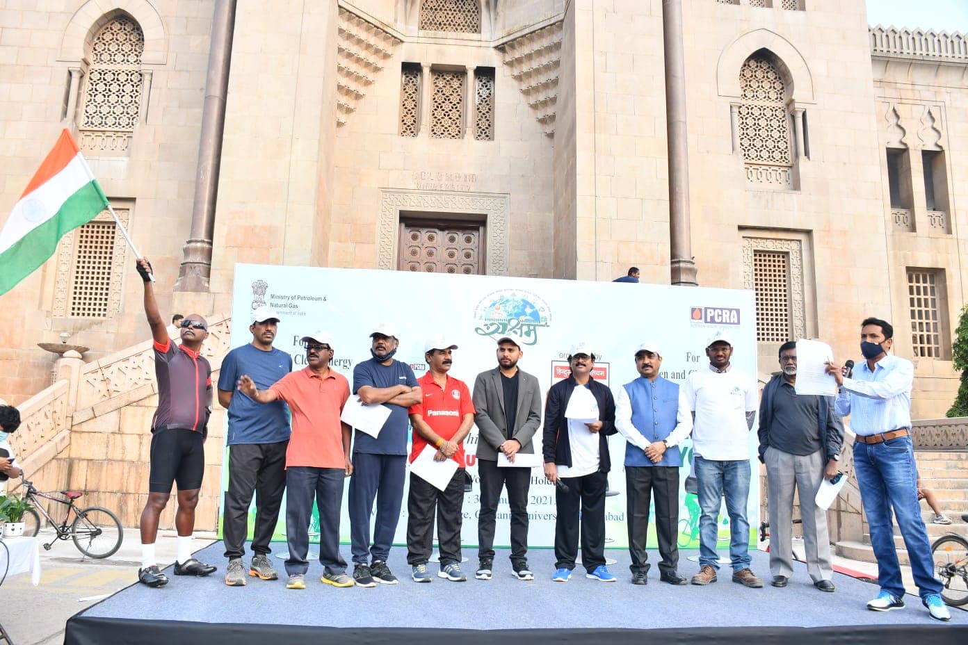 Bobba Ravinder Reddy on stage with a flag at a PCRA Green and Clean Energy cycling event