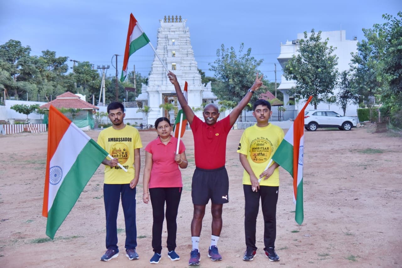 Family group holding Indian flags in front of a temple gopuram
