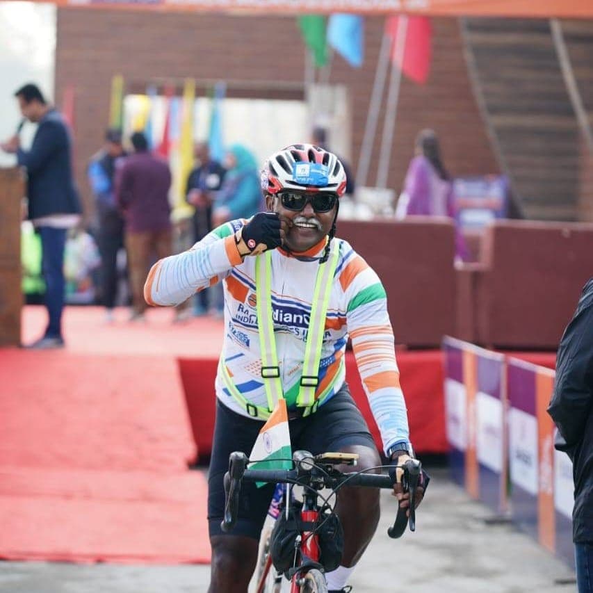 Bobba Ravinder Reddy smiling at the finish line of the IndianOil Race Across India, giving a thumbs-up