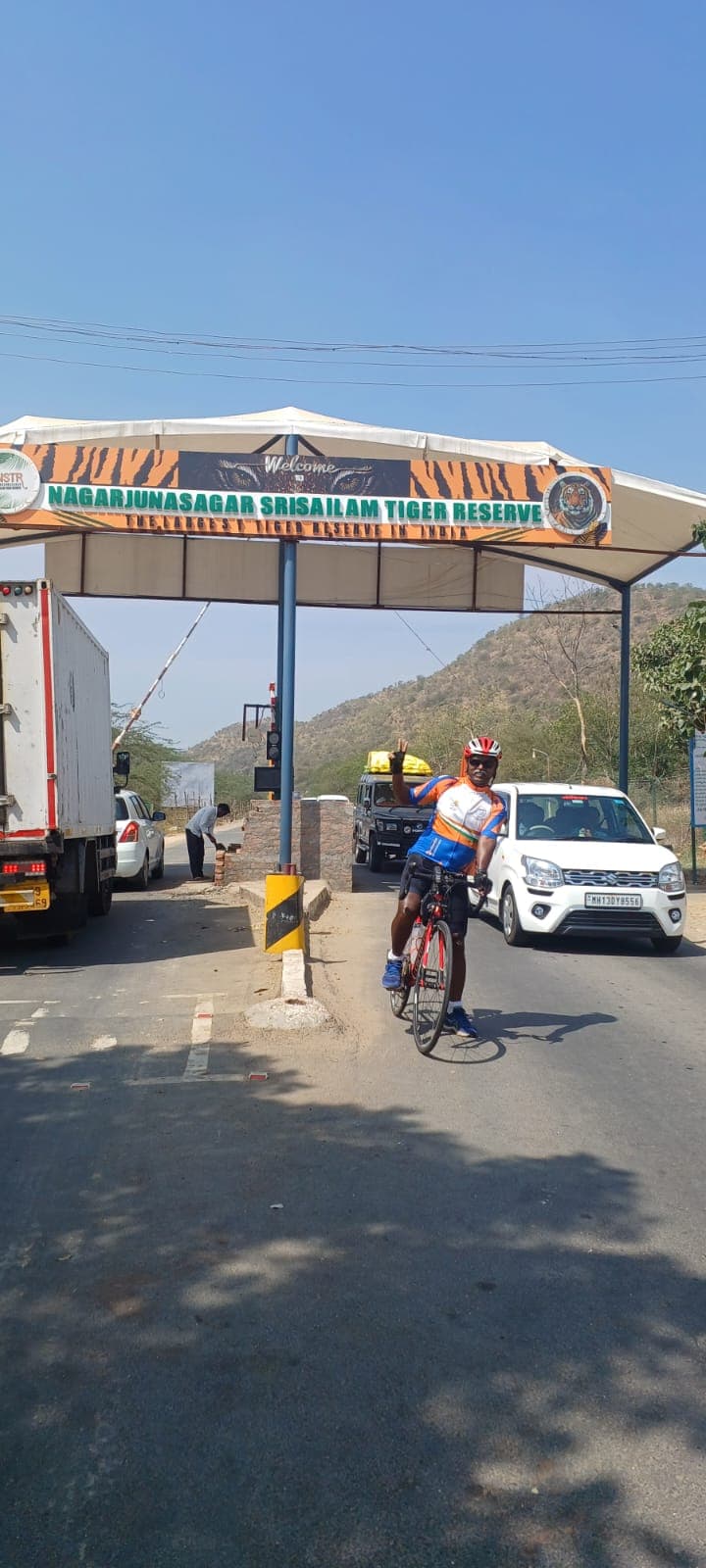 Bobba Ravinder Reddy cycling past the Nagarjunasagar Srisailam Tiger Reserve welcome arch