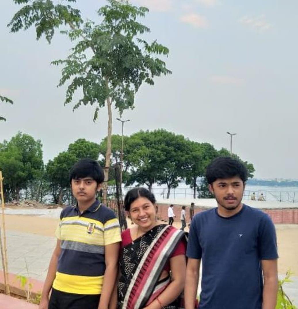 Two sons and their mother standing by a lakeside promenade