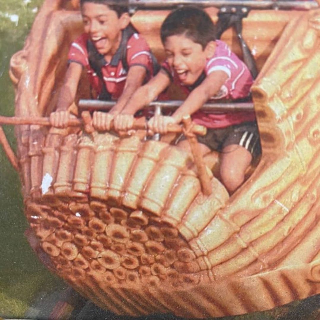 Childhood photo of the two sons laughing together on an amusement park ride